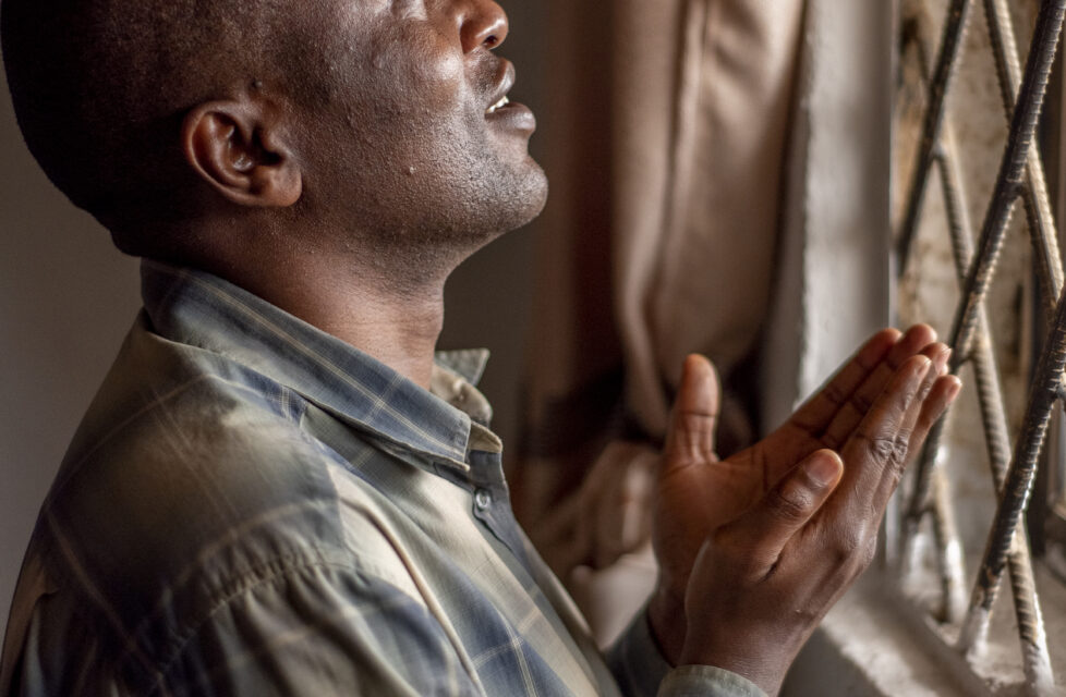 Nigerian Man Praying at a window